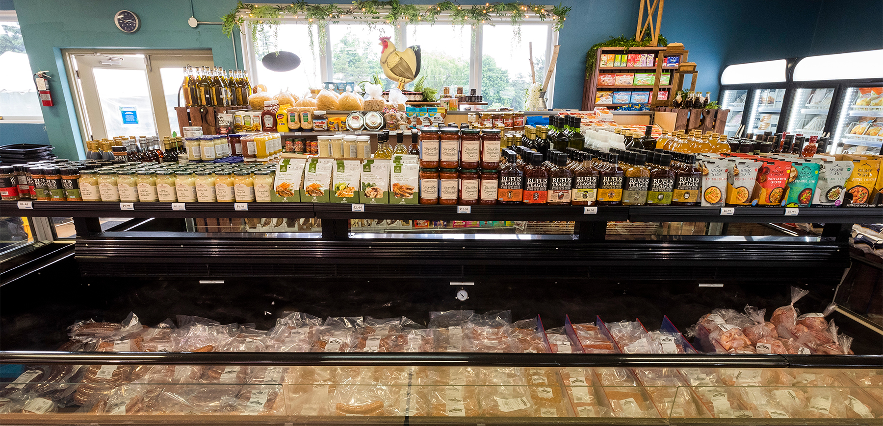 The interior of Agram Meats and Culinary Boutique. There is a cooler of deli meat.